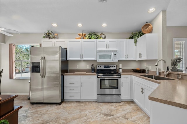 kitchen featuring sink, white cabinetry, plenty of natural light, and appliances with stainless steel finishes