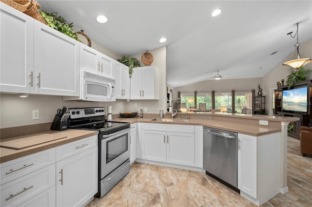 kitchen with stainless steel appliances, kitchen peninsula, sink, white cabinetry, and lofted ceiling