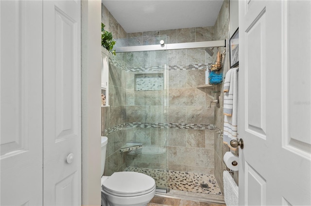 bathroom featuring an enclosed shower and toilet