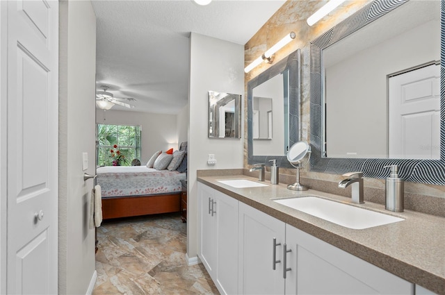 bathroom with a textured ceiling, ceiling fan, and vanity