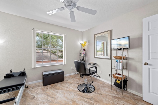 living area featuring a textured ceiling and ceiling fan