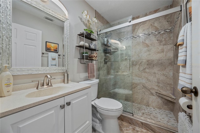 bathroom featuring toilet, a shower with door, and vanity