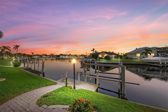 dock area with a lawn and a water view