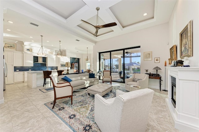 living room with a towering ceiling, ornamental molding, coffered ceiling, ceiling fan, and beamed ceiling