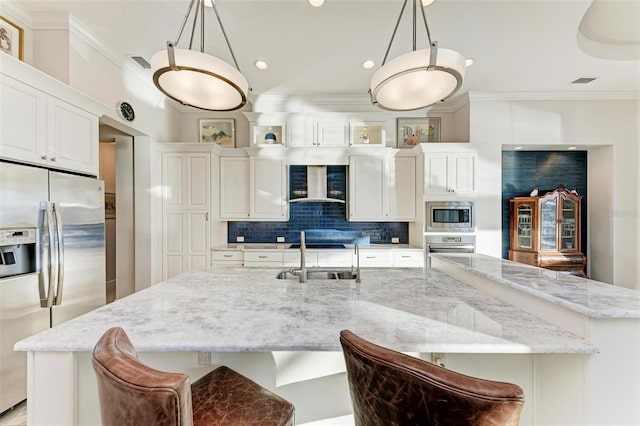 kitchen featuring white cabinets, appliances with stainless steel finishes, a spacious island, and sink