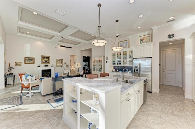 kitchen with white cabinetry, sink, ceiling fan, coffered ceiling, and a kitchen island with sink