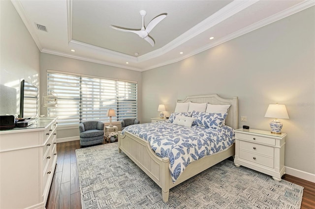 bedroom featuring light hardwood / wood-style floors, ceiling fan, crown molding, and a tray ceiling