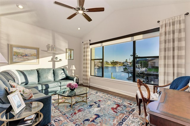 living room with hardwood / wood-style floors, ceiling fan, a water view, and vaulted ceiling