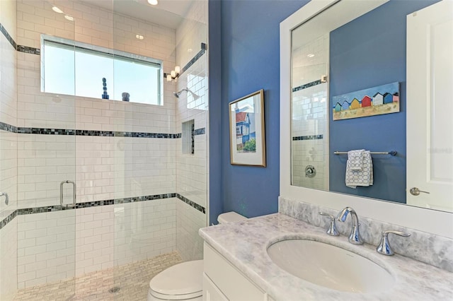 bathroom featuring walk in shower, vanity, and toilet