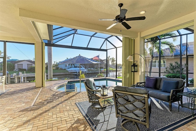 view of patio / terrace with an outdoor living space, ceiling fan, and a lanai