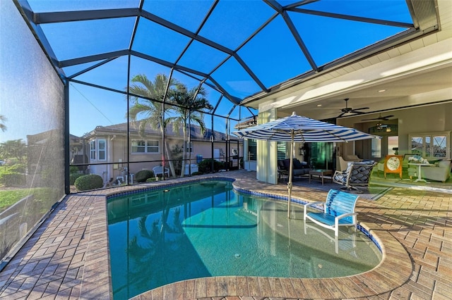 view of swimming pool with ceiling fan, a lanai, an outdoor living space, and a patio