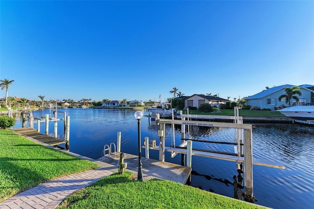 view of dock with a lawn and a water view