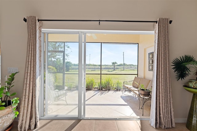 entryway with a rural view and tile patterned floors