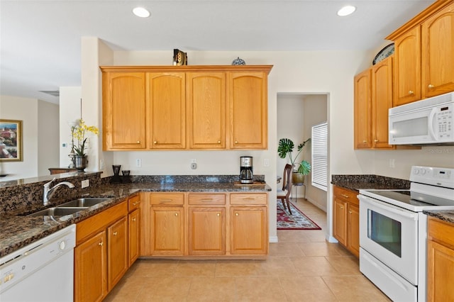 kitchen featuring kitchen peninsula, white appliances, sink, dark stone countertops, and light tile patterned flooring