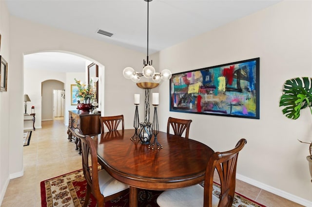 dining space with light tile patterned floors and a chandelier