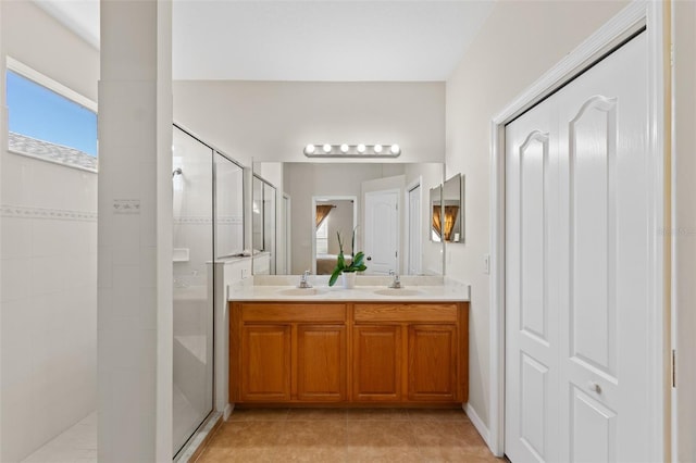 bathroom featuring a tile shower, tile patterned flooring, and vanity