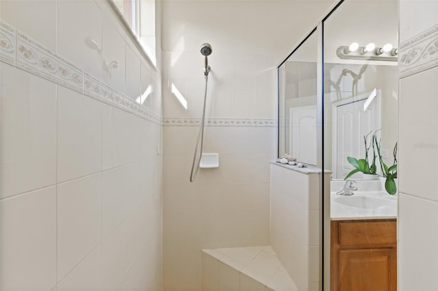 bathroom featuring tiled shower and vanity