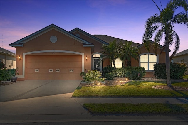 ranch-style house featuring a garage and a yard