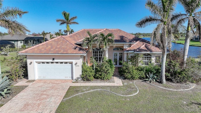 mediterranean / spanish-style home with a water view and a garage