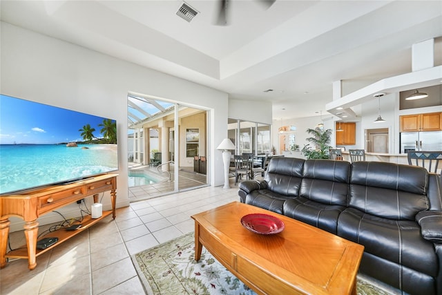 living room featuring ceiling fan, a wealth of natural light, and light tile patterned flooring