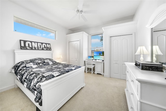 carpeted bedroom featuring multiple windows, ceiling fan, and multiple closets