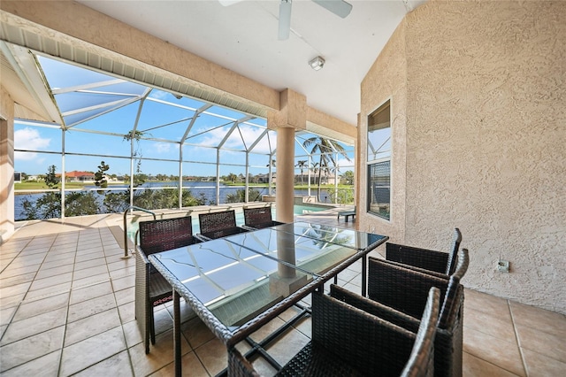 view of patio featuring a water view, ceiling fan, and a lanai