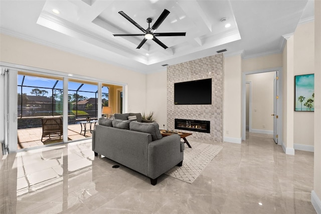 living room featuring a tray ceiling, a stone fireplace, ceiling fan, and ornamental molding