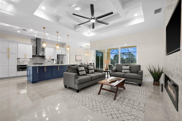 living room with ceiling fan, a raised ceiling, crown molding, and coffered ceiling