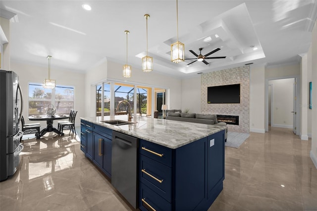 kitchen featuring blue cabinetry, sink, a fireplace, a center island with sink, and appliances with stainless steel finishes