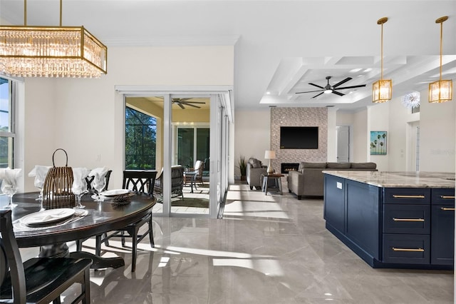 dining room featuring ceiling fan, a large fireplace, and ornamental molding