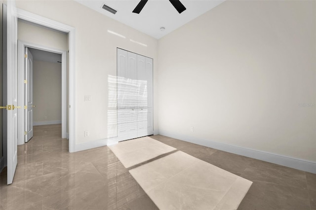 unfurnished bedroom with ceiling fan and a closet