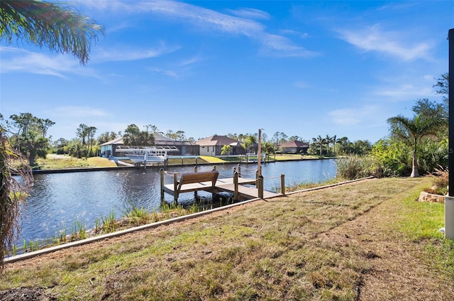 dock area with a water view and a lawn