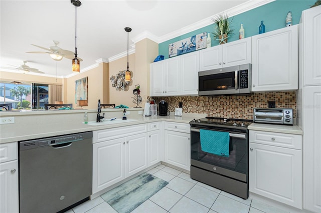 kitchen featuring white cabinetry, sink, hanging light fixtures, stainless steel appliances, and crown molding