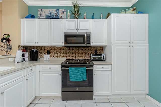 kitchen featuring white cabinetry, stainless steel appliances, tasteful backsplash, crown molding, and light tile patterned flooring