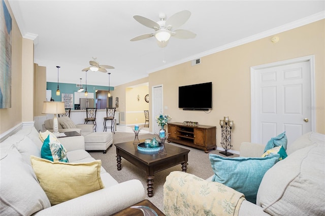 living room with ceiling fan, carpet floors, and crown molding