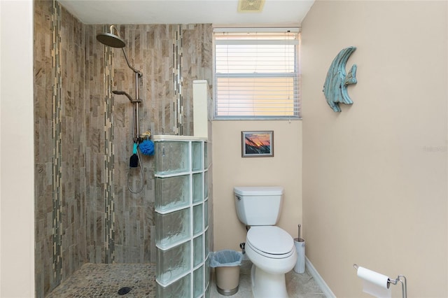 bathroom with tiled shower, tile patterned floors, and toilet