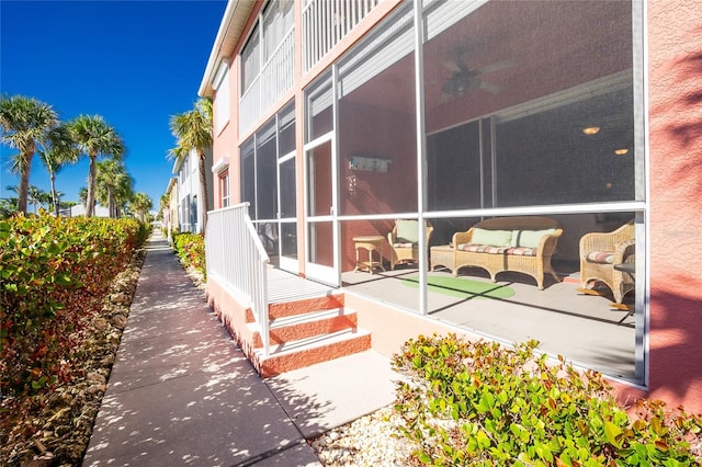 view of property exterior featuring a sunroom, an outdoor living space, and a patio