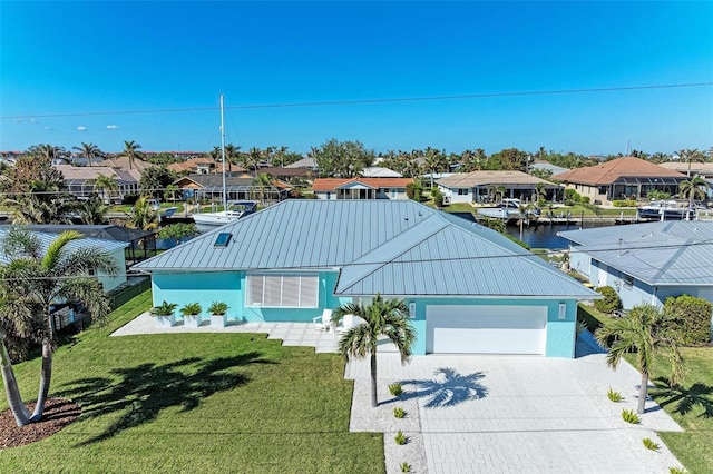 view of front of home featuring a front lawn, a water view, and a garage