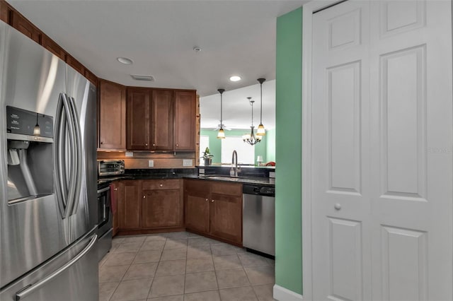 kitchen with pendant lighting, stainless steel appliances, light tile patterned floors, and sink