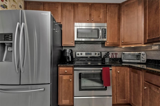 kitchen with dark stone counters, backsplash, and stainless steel appliances