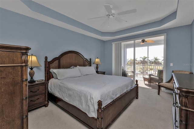 bedroom with a raised ceiling, ceiling fan, access to exterior, and light carpet