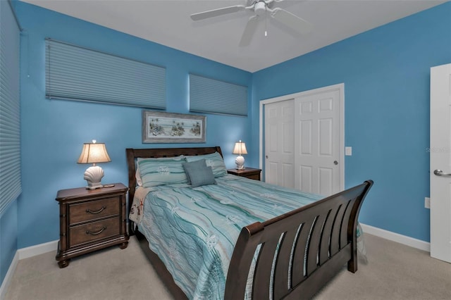 bedroom featuring ceiling fan, a closet, and light colored carpet