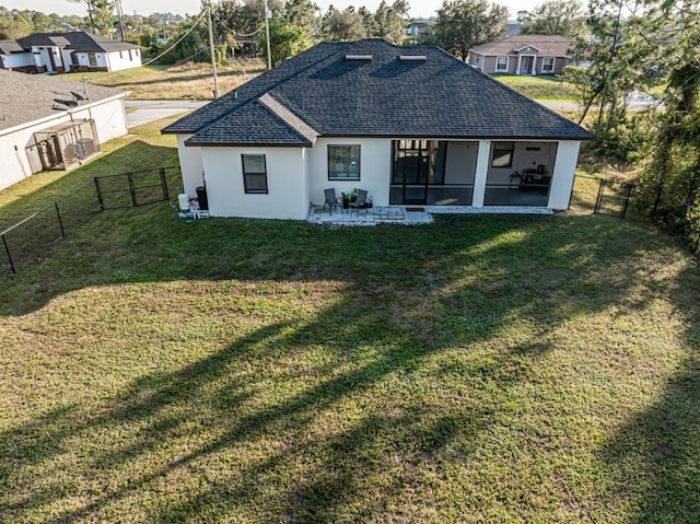 rear view of house with a patio area, a yard, and a sunroom