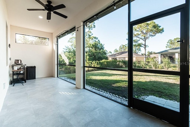 unfurnished sunroom with ceiling fan