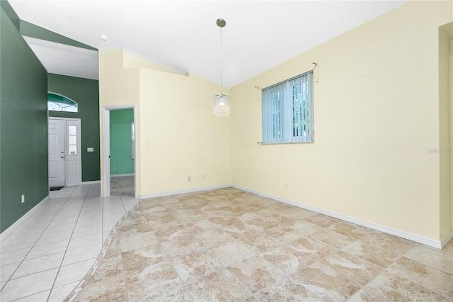 spare room featuring tile patterned floors and lofted ceiling