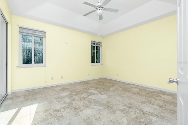 spare room featuring ceiling fan and a tray ceiling