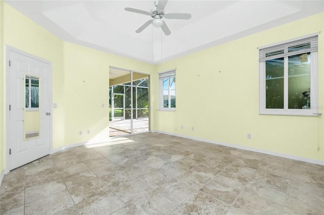 spare room with a raised ceiling and ceiling fan