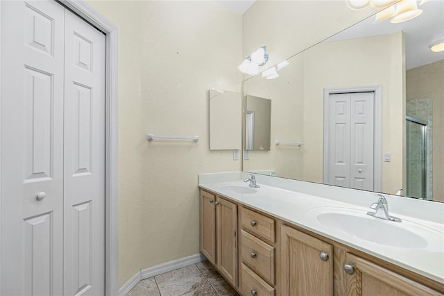 bathroom with tile patterned floors, vanity, and a shower with door