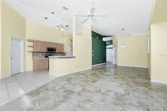 kitchen featuring ceiling fan, kitchen peninsula, backsplash, and high vaulted ceiling