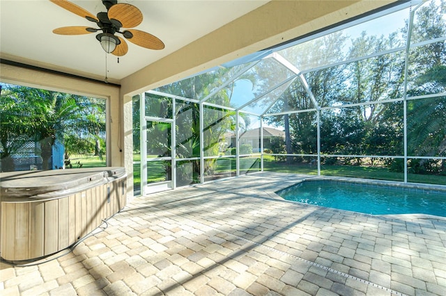 view of pool featuring glass enclosure, a hot tub, ceiling fan, and a patio area